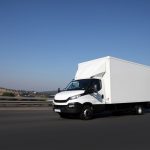 Dynamische Fahrt von einem Transportfahrzeug mit Dorf im Hintergrund